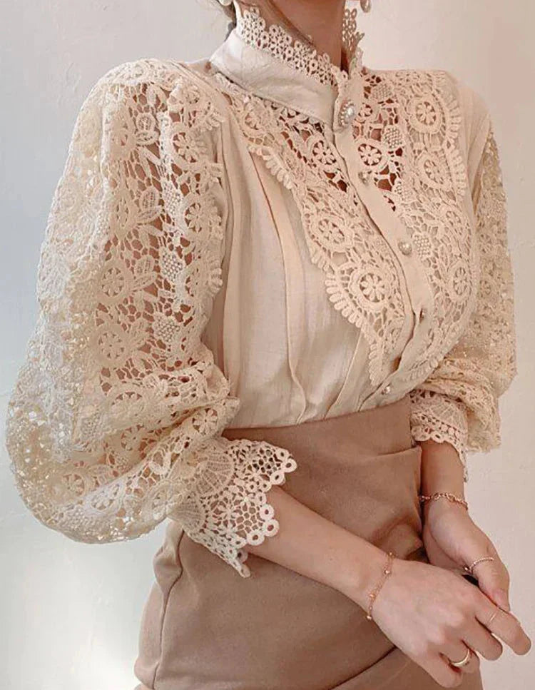 Blusa elegante in pizzo beige con maniche a sbuffo, dettagli floreali e colletto alto. Moda femminile, abbigliamento chic, stile vintage.