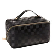 Borsa da viaggio nera con motivo a scacchi, manico superiore e cerniera dorata. Elegante e pratica per organizzare accessori e cosmetici.