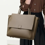 Borsa a mano in pelle marrone, design elegante e moderno, indossata da una persona. Accessorio moda donna, ideale per ufficio e occasioni formali.