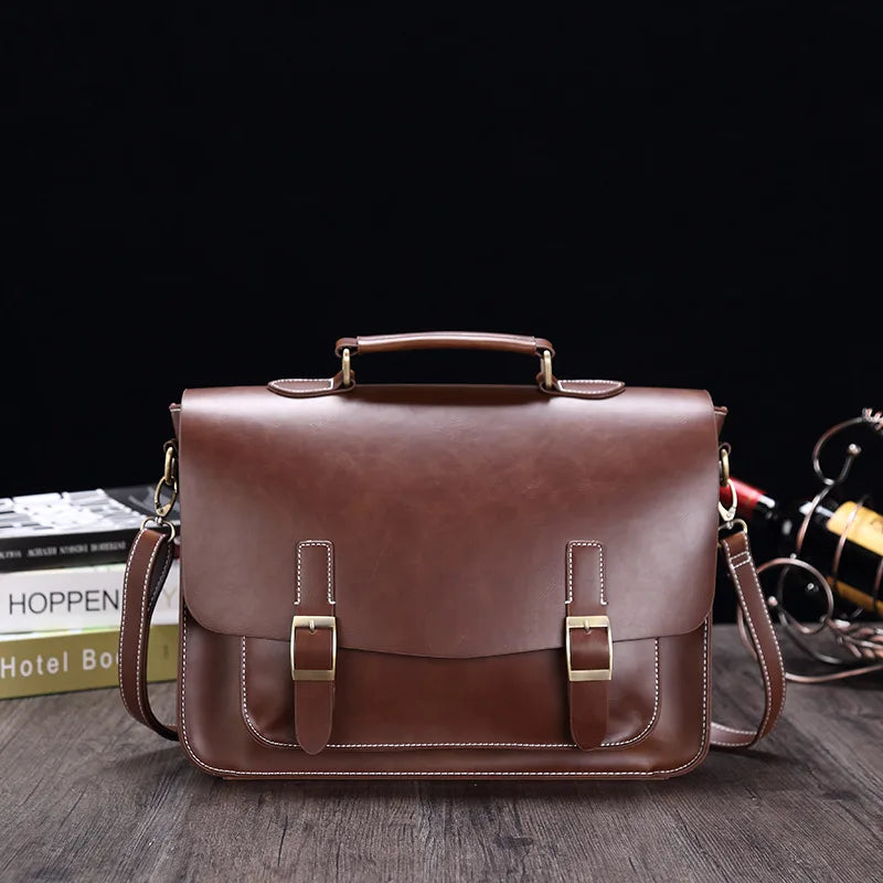 Borsa a tracolla in pelle marrone con fibbie dorate, design elegante e spazioso, ideale per lavoro e viaggio. Accessorio moda uomo/donna.