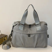 Borsa a tracolla grigia unisex, design moderno, tessuto resistente, doppia cerniera, manici rinforzati, ideale per viaggio e uso quotidiano.