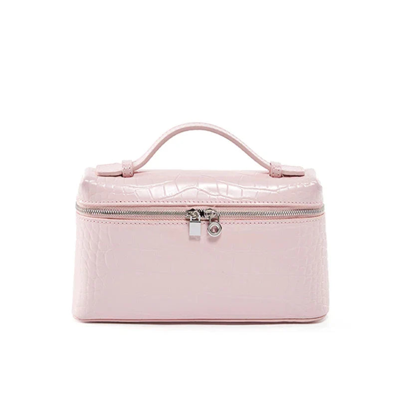 Borsa cosmetica rosa in pelle sintetica con texture coccodrillo, chiusura a zip e manico superiore. Elegante e pratica per viaggi e organizzazione.