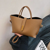 Borsa a mano in pelle marrone, design elegante con manici doppi e chiusura a fibbia dorata, perfetta per moda donna e accessori di lusso.