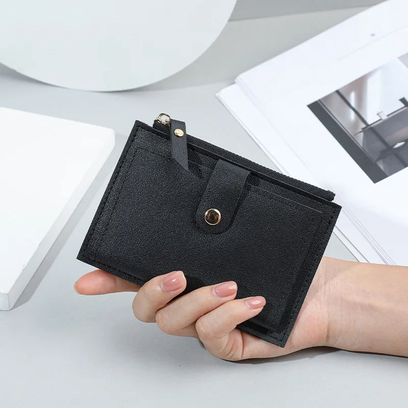 Portafoglio nero in pelle sintetica, design minimalista, tenuto in mano su sfondo bianco. Accessorio moda elegante, ideale per uomo e donna.