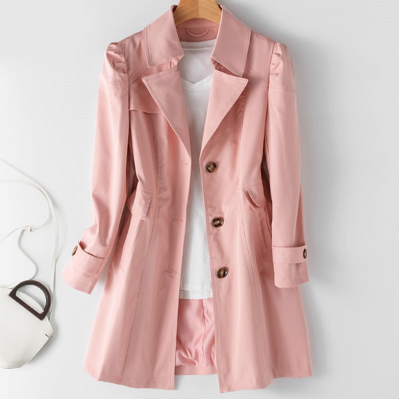 Cappotto rosa da donna elegante, con bottoni marroni, appeso su gruccia. Include maglietta bianca e borsa bianca. Moda femminile autunnale.