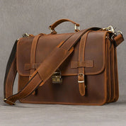 Elegante borsa ventiquattrore in pelle marrone con tracolla regolabile, chiusura a fibbia e manico superiore. Ideale per lavoro e viaggi d'affari.