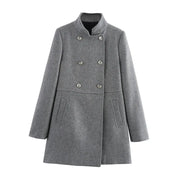 Cappotto grigio donna in lana, doppio petto, elegante, con bottoni metallici, collo alto, tasche laterali. Moda autunno inverno.