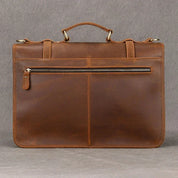 Elegante cartella in pelle marrone con manico superiore, tasca frontale con cerniera, ideale per lavoro e ufficio. Design classico e funzionale.