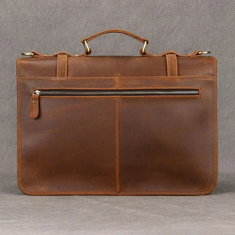 Elegante cartella in pelle marrone con manico superiore, tasca frontale con cerniera, ideale per lavoro e ufficio. Design classico e funzionale.