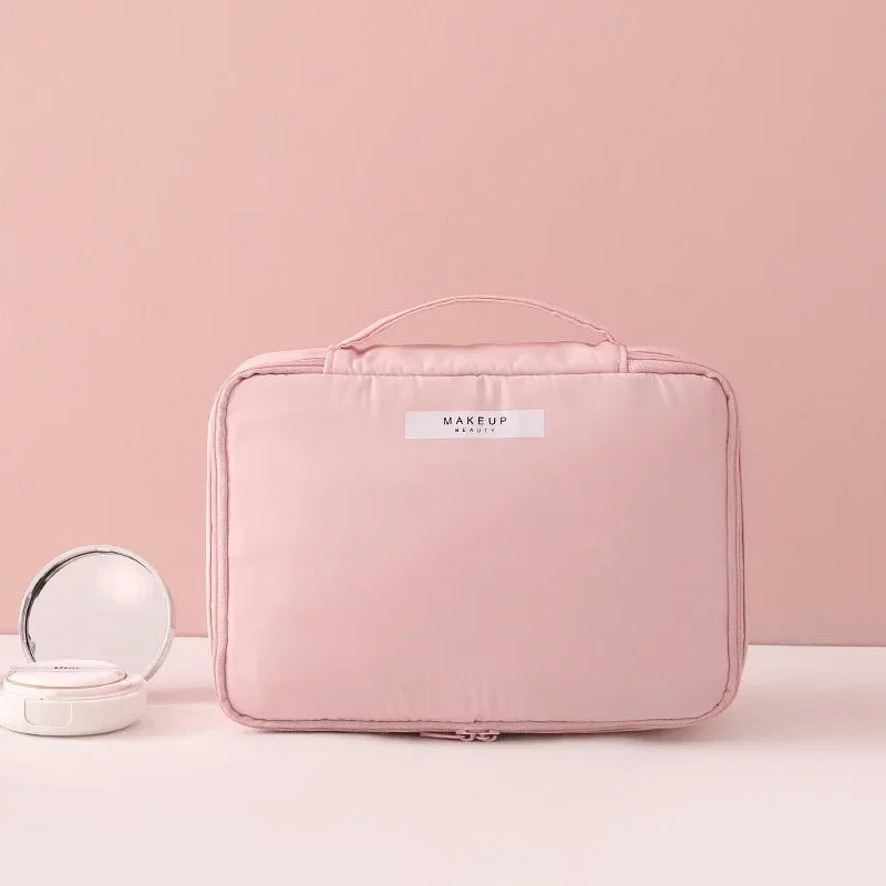 Borsa trucco rosa con manico, design elegante e compatto, ideale per organizzare cosmetici. Perfetta per viaggi e uso quotidiano.
