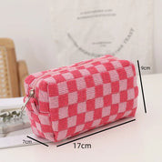 Astuccio a scacchi rosa e bianco, dimensioni 17x9x7 cm, su tavolo bianco. Design moderno, ideale per scuola o ufficio. Accessorio moda pratico.