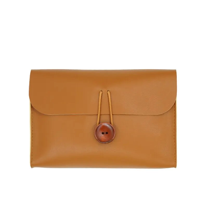 Borsa a tracolla in pelle marrone chiaro con chiusura a bottone in legno, design elegante e minimalista, accessorio moda donna, ideale per ogni occasione.