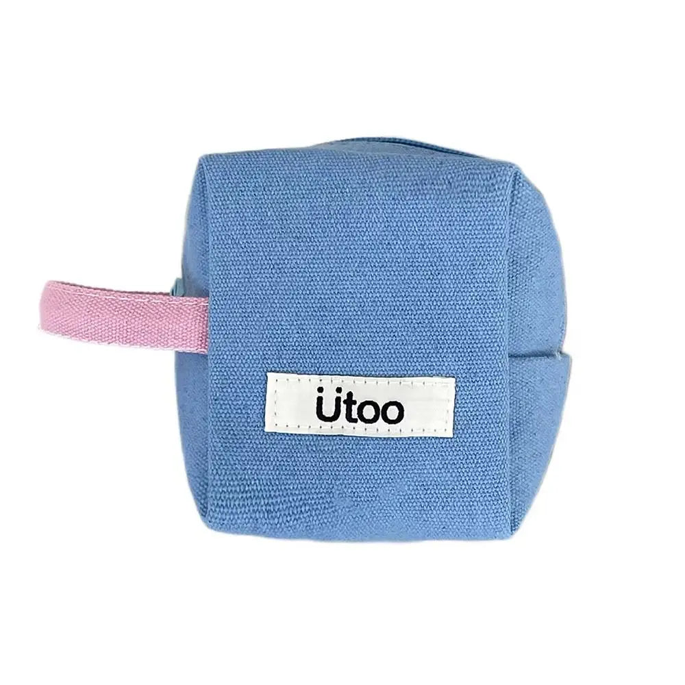 Cubo di stoffa blu con manico rosa, etichetta "utoo". Giocattolo educativo per bambini, morbido e sicuro. Accessorio per sviluppo sensoriale.
