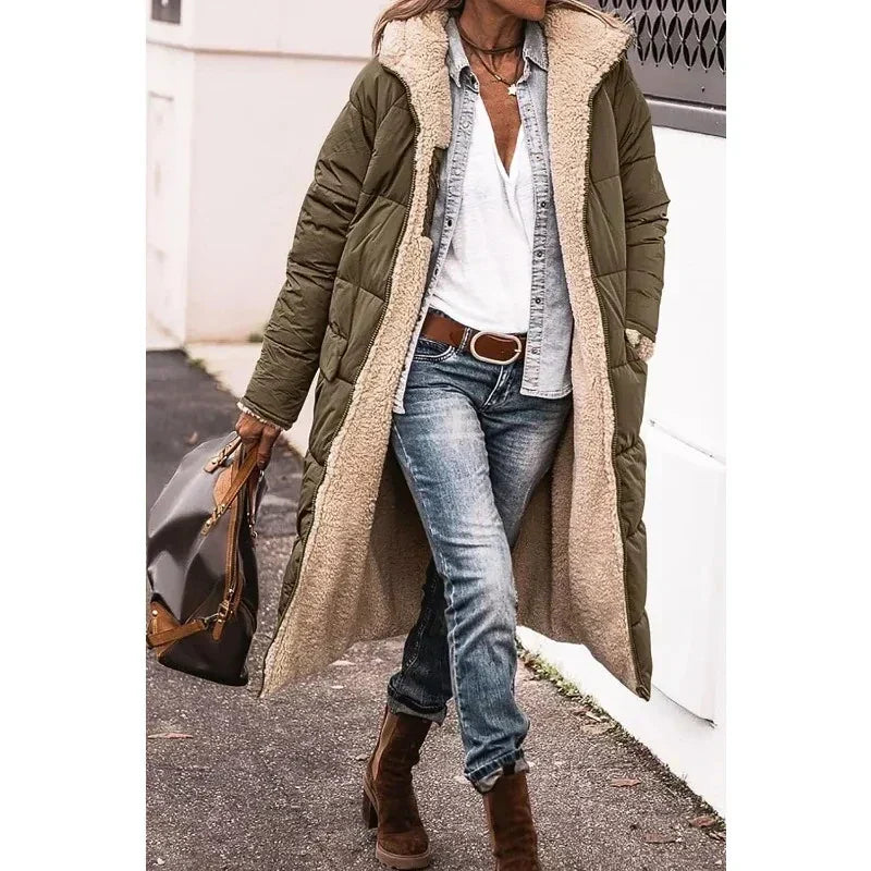 Donna con cappotto lungo verde imbottito, camicia bianca, jeans e stivali marroni. Moda invernale casual, stile urbano chic.