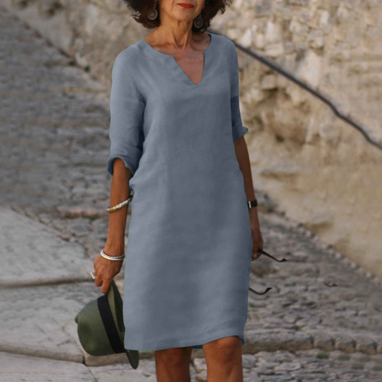 Abito estivo donna grigio, maniche a tre quarti, scollo a V, indossato da una donna su strada acciottolata. Elegante e casual.