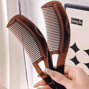 Due pettini marroni in plastica, design ergonomico, impugnati da una mano femminile. Ideali per capelli lisci e ricci. Accessori per cura capelli.