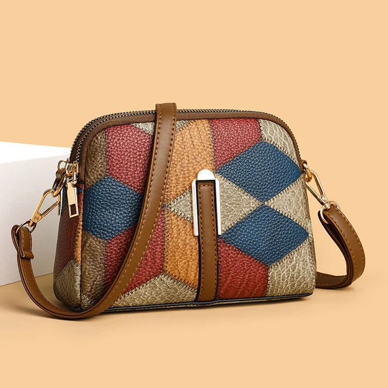 Borsa a tracolla in pelle multicolore con motivo geometrico, chiusura a zip, cinturino regolabile, design elegante e moderno.