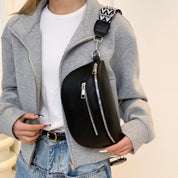 Giacca grigia casual, borsa a tracolla nera con cerniere, cinturino decorato, moda donna, stile urbano, abbigliamento autunnale, outfit trendy.