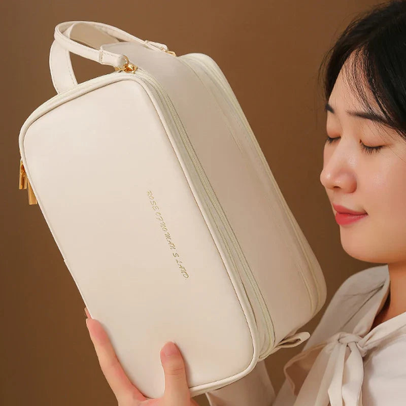 Donna con borsa cosmetica bianca, elegante e spaziosa, con cerniera dorata. Ideale per viaggi, organizzazione trucco e accessori.