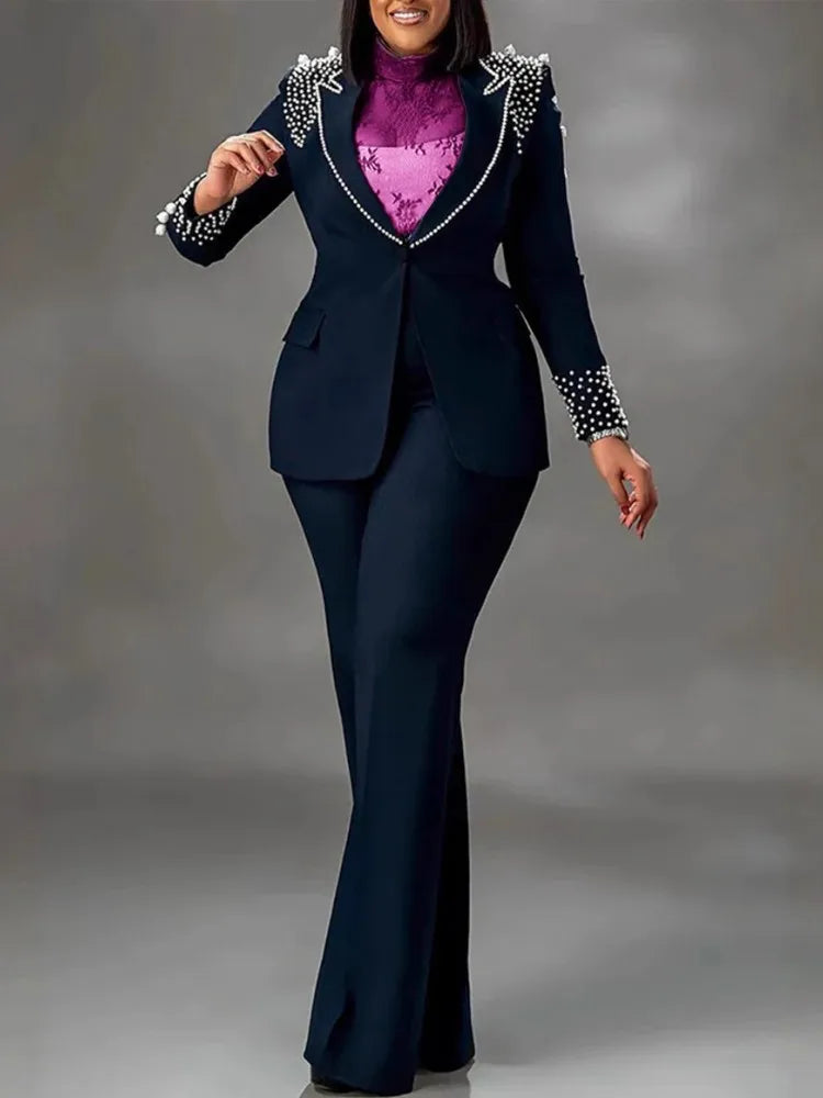 Completo donna elegante blu scuro con perle, giacca e pantaloni svasati, camicia viola. Abbigliamento formale moda femminile.