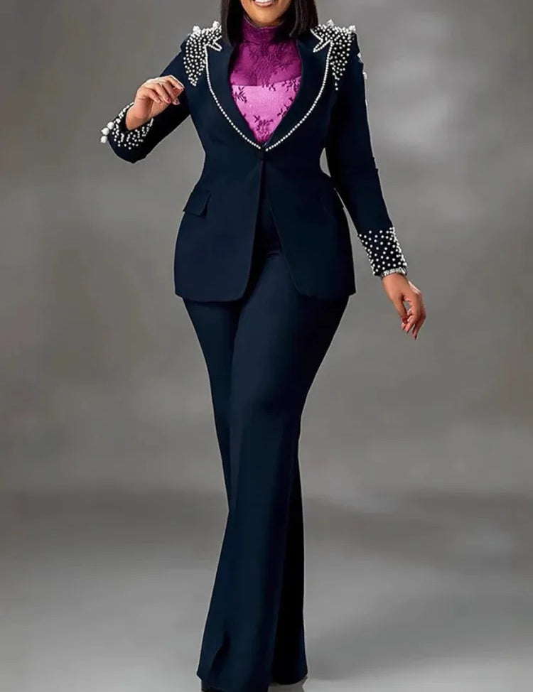 Completo donna elegante blu scuro con perle, giacca e pantaloni, camicia viola, moda formale, abbigliamento da ufficio, stile sofisticato.