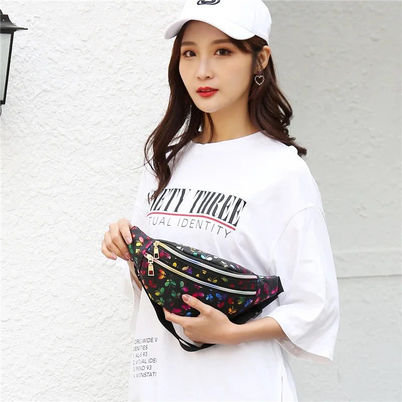 Giovane donna con cappellino bianco e maglietta oversize, indossa marsupio nero floreale. Moda casual, accessori trendy, street style femminile.