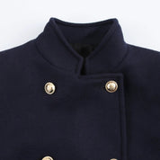 Cappotto blu scuro in lana con colletto alto e bottoni dorati, stile militare elegante, moda uomo autunno inverno, abbigliamento formale.