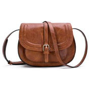 Borsa a tracolla in pelle marrone, design vintage con fibbia argentata. Accessorio moda donna elegante e versatile.