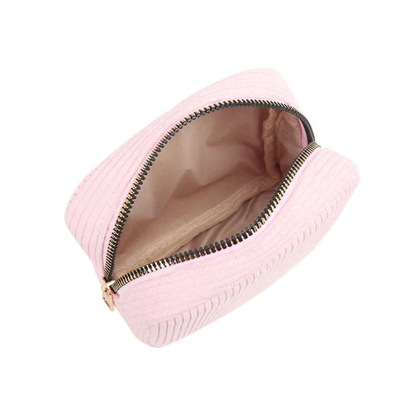 Astuccio cosmetico rosa in tessuto con cerniera aperta, design elegante e compatto, ideale per trucchi e accessori da viaggio.