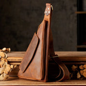 Zaino monospalla in pelle marrone vintage, design elegante e compatto, ideale per uomo, perfetto per viaggi e uso quotidiano.