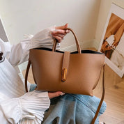 Borsa a mano in pelle marrone, design elegante con chiusura a bottone, indossata da una donna. Accessorio moda femminile, stile casual chic.
