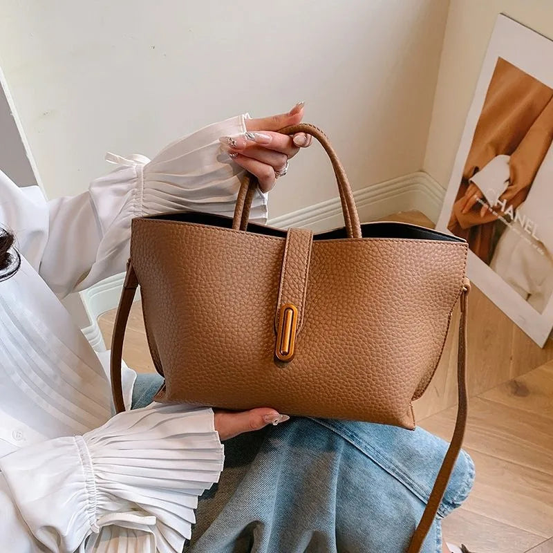 Borsa a mano in pelle marrone, design elegante con chiusura a bottone, indossata da una donna. Accessorio moda femminile, stile casual chic.
