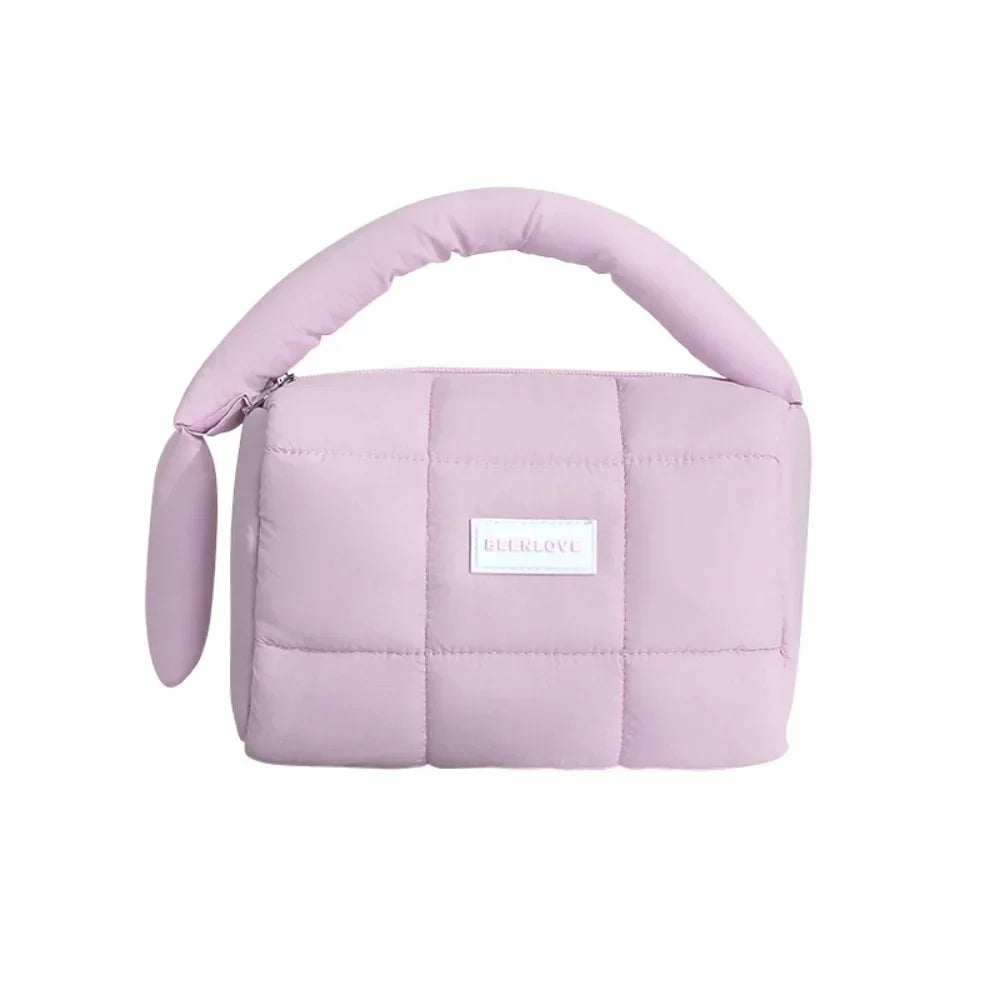 Borsa a mano trapuntata rosa pastello, design moderno, manico imbottito, ideale per moda femminile. Accessorio elegante e versatile.