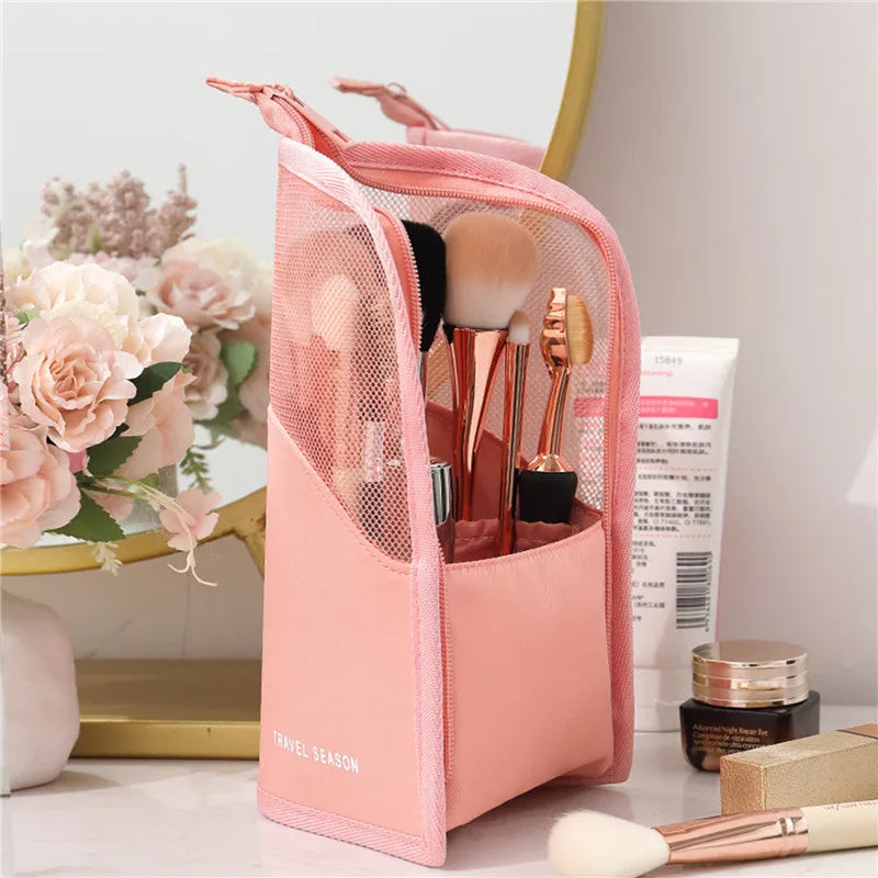 Astuccio da viaggio rosa per pennelli trucco, con fiori decorativi e prodotti cosmetici sullo sfondo. Accessorio beauty organizzato ed elegante.