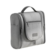 Borsa da viaggio grigia con manico, tasche multiple e cerniere, ideale per organizzare articoli da toeletta. Design compatto e funzionale.