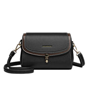Borsa a tracolla in pelle nera con dettagli marroni, chiusura a fibbia dorata e tracolla regolabile. Elegante accessorio moda donna.
