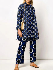 Donna con abito e pantaloni blu a cerchi bianchi, borsa beige a tracolla, sandali marroni. Moda femminile, abbigliamento casual elegante.