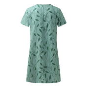 Abito verde a maniche corte con motivo foglie, design elegante e moderno, perfetto per la moda estiva femminile. Tessuto leggero e confortevole.
