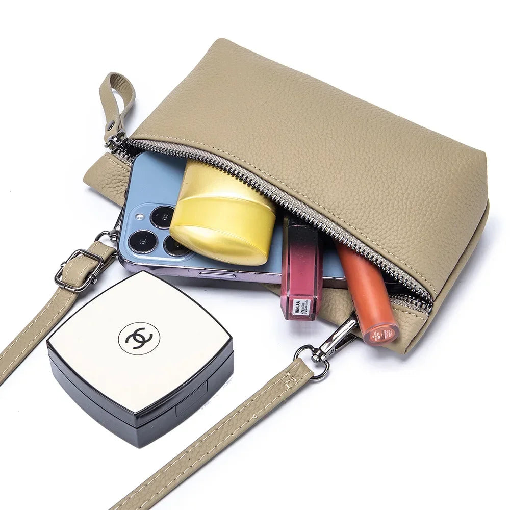 Borsa a tracolla beige in pelle con smartphone, rossetti e cipria Chanel. Accessori moda donna, elegante e pratica per uso quotidiano.