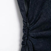 Vestito nero in denim con arricciature laterali, chiusura a zip nascosta. Elegante e moderno, perfetto per occasioni casual e serali.