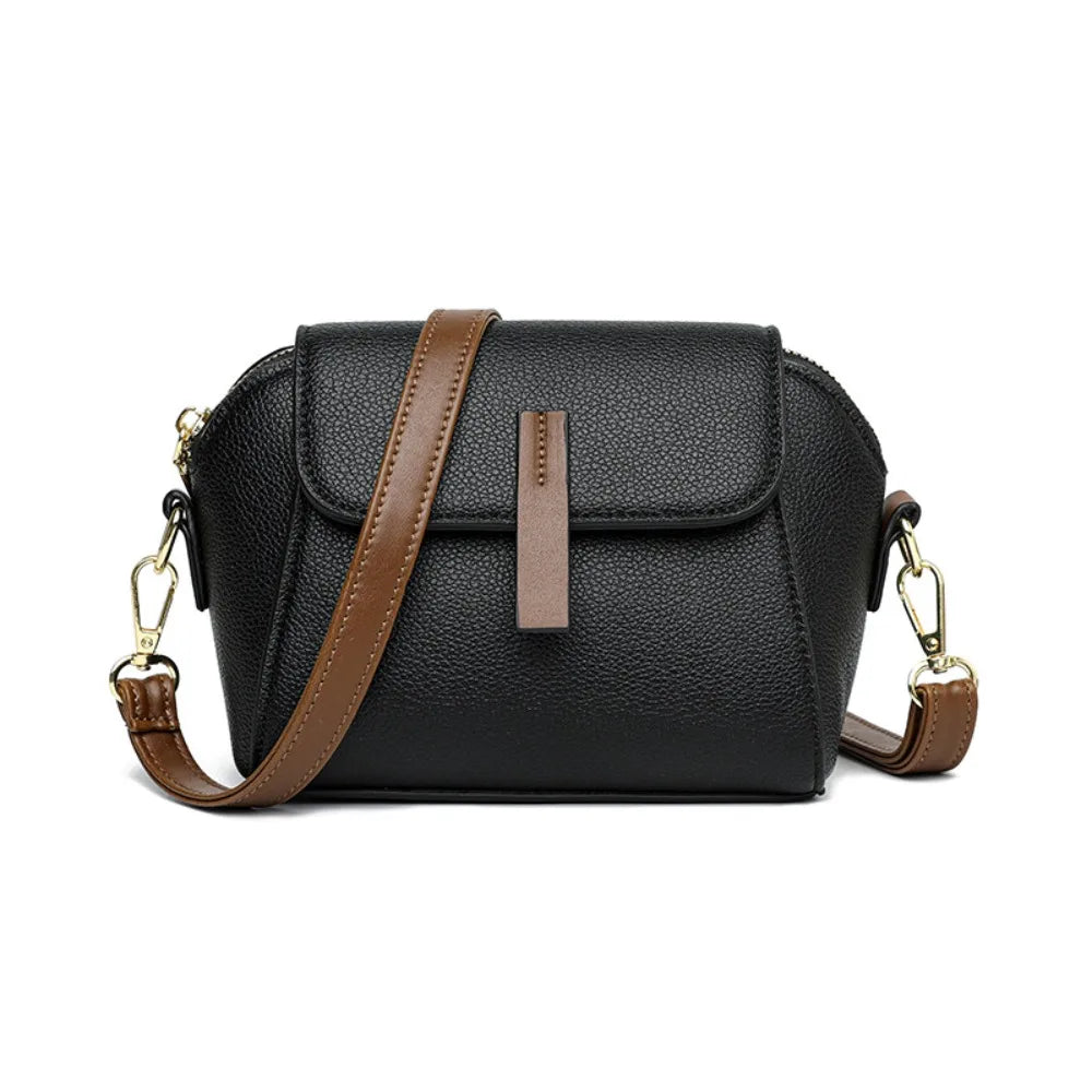 Borsa a tracolla in pelle nera con dettagli marroni, chiusura a patta, tracolla regolabile, design elegante e moderno. Accessorio moda donna.