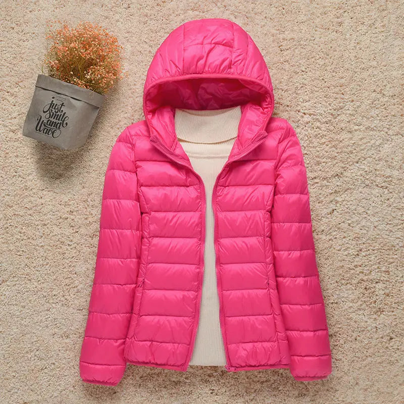 Giacca invernale rosa con cappuccio, imbottita, su sfondo beige. Moda donna, abbigliamento caldo, stile casual. Perfetta per l'inverno.