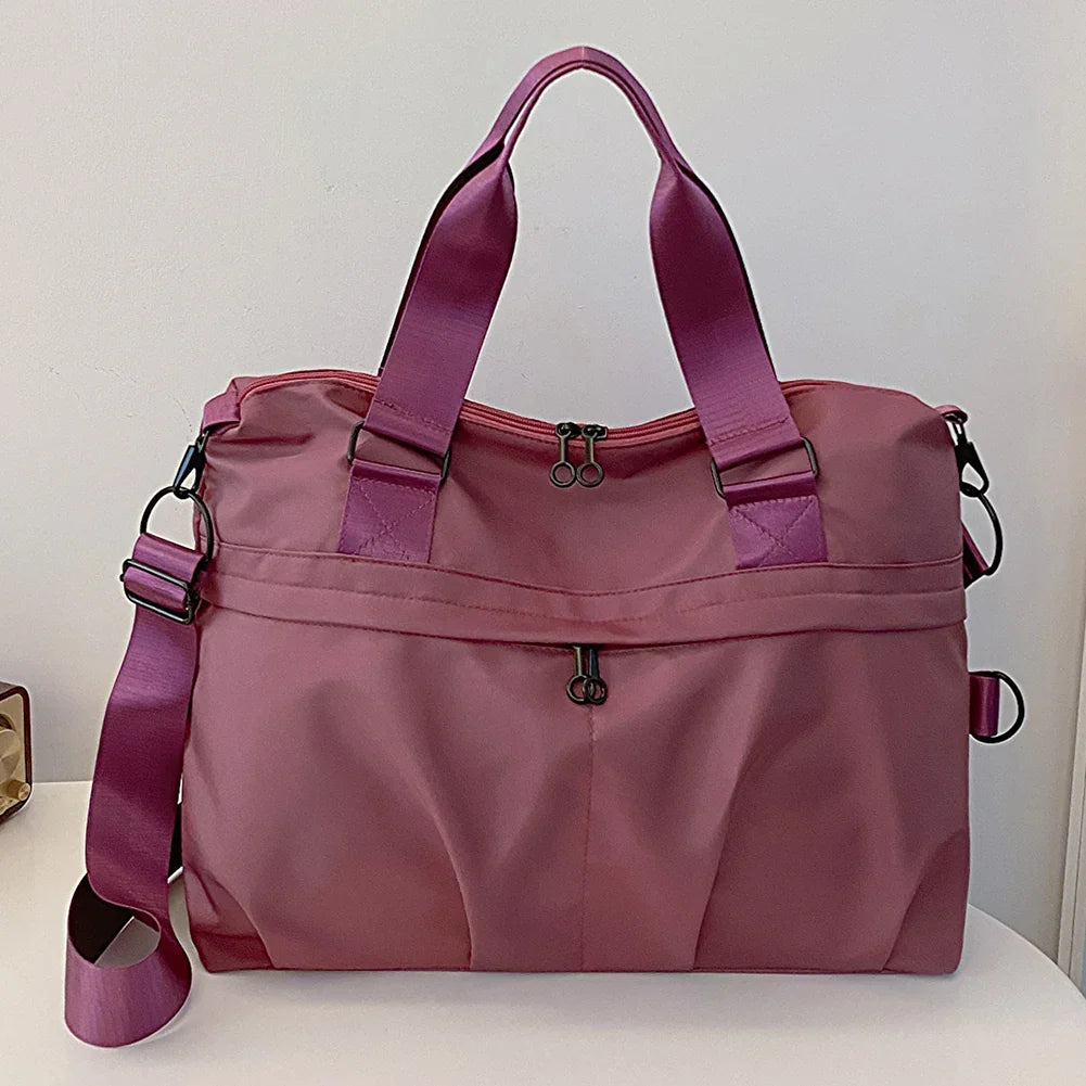 Borsa da viaggio rosa in nylon con manici e tracolla regolabile, design elegante e spazioso, ideale per viaggi e uso quotidiano.