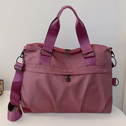 Borsa da viaggio rosa in nylon con manici e tracolla regolabile, design elegante e spazioso, ideale per viaggi e uso quotidiano.