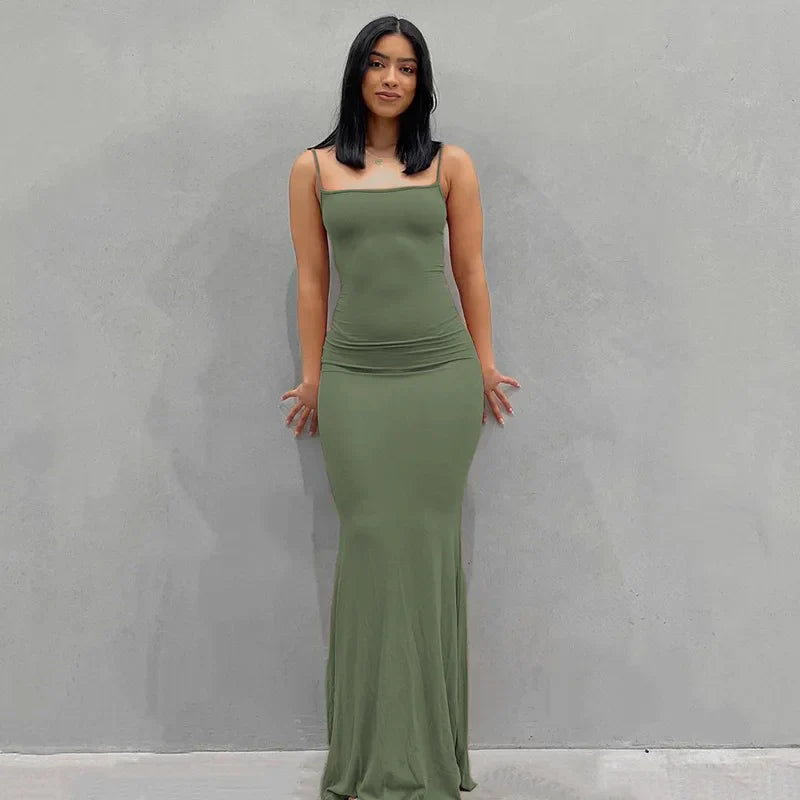Abito lungo verde oliva aderente, senza maniche, indossato da una donna su sfondo grigio. Elegante e moderno, perfetto per eventi serali.