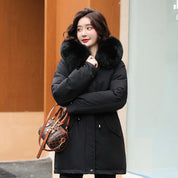 Donna con cappotto invernale nero con collo in pelliccia, borsa a tracolla marrone. Moda invernale, abbigliamento caldo, stile elegante.