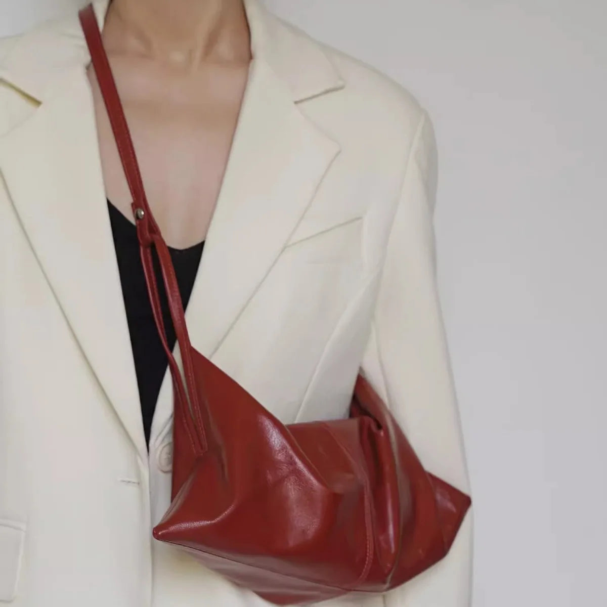 Borsa a tracolla in pelle rossa su giacca bianca elegante, moda donna, accessorio di tendenza, stile minimalista, abbigliamento casual chic.