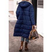 Donna con cappotto lungo blu, stivali marroni e borsa in pelle. Moda invernale, abbigliamento casual, passeggiata urbana.