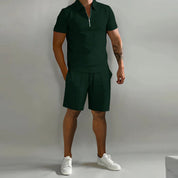 Completo estivo uomo verde scuro, polo con zip e pantaloncini, scarpe bianche. Abbigliamento casual elegante, moda maschile estiva.