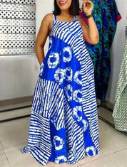 Abito lungo estivo blu con motivo tie-dye bianco, senza maniche, tasche laterali, indossato da donna in negozio di moda.